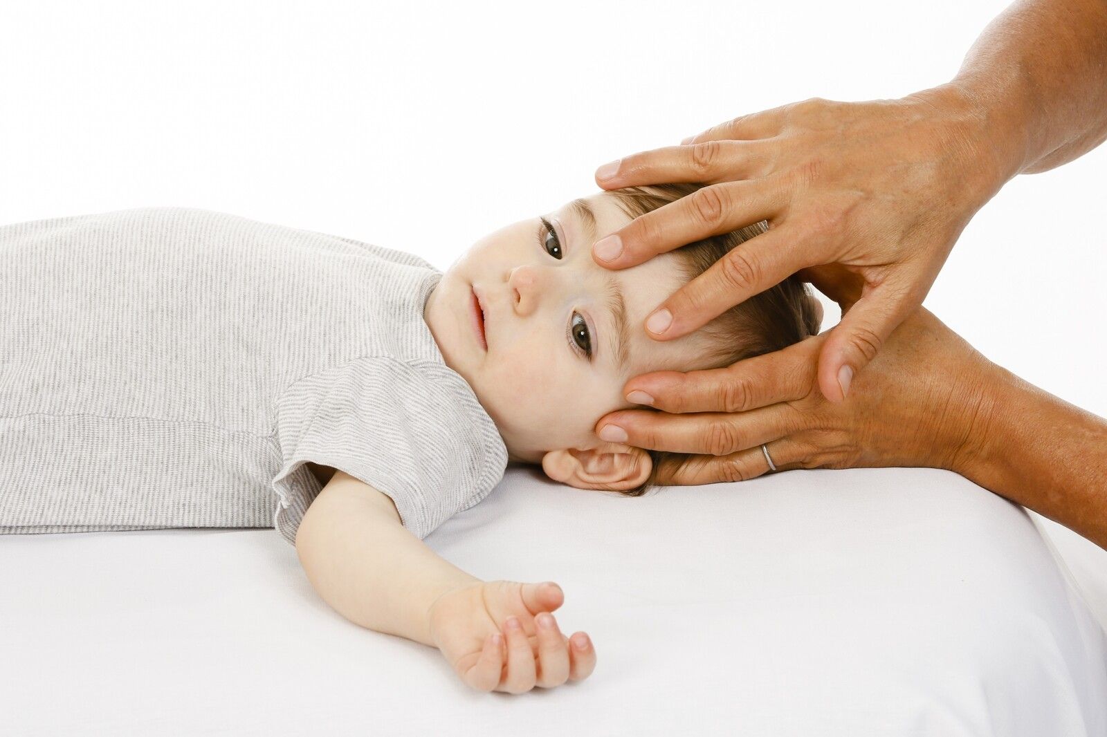 Eine osteopathische Behandlung am Kopf bei einem Kleinkind